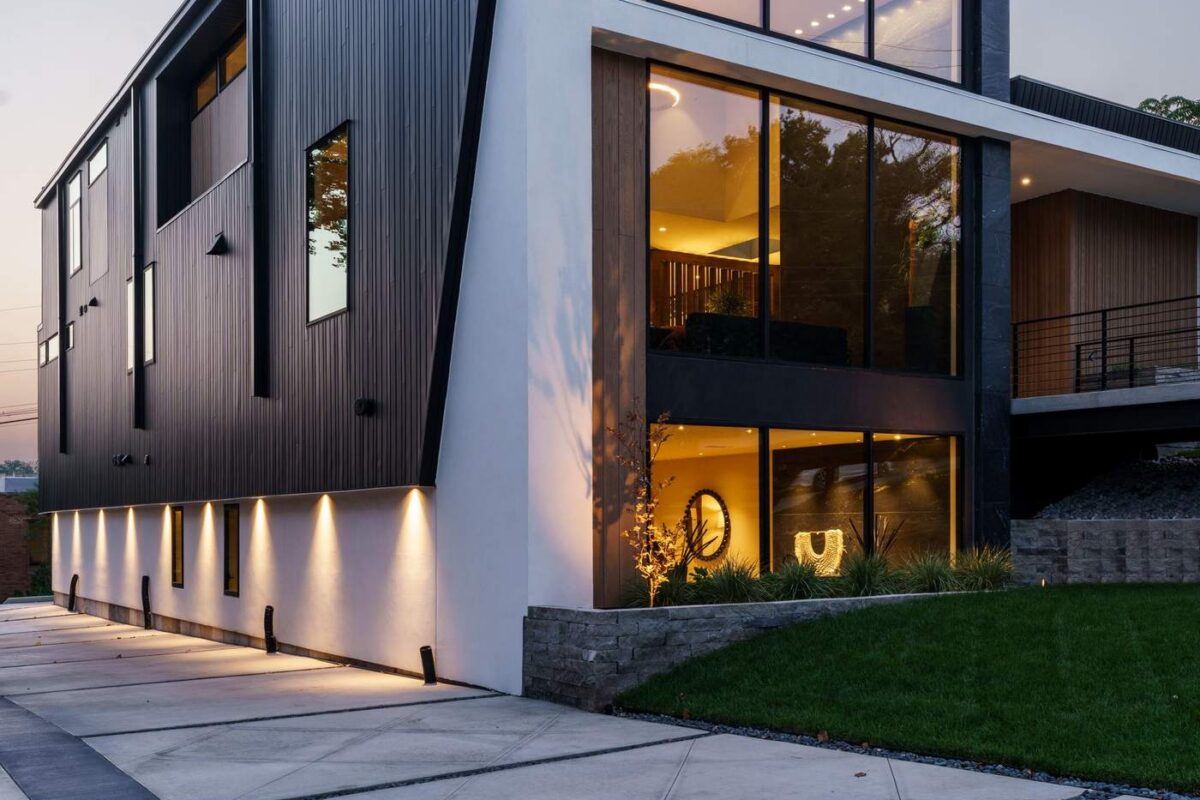 Angular contemporary custom home exterior illuminated at dusk, Hickok Homes new construction