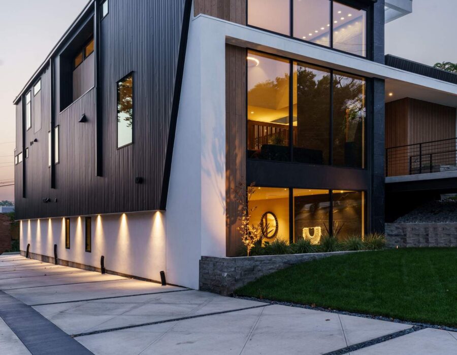 Angular contemporary custom home exterior illuminated at dusk, Hickok Homes new construction