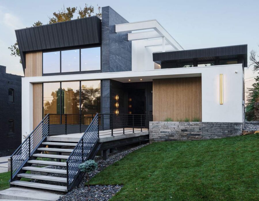 Contemporary custom home exterior with black metal cladding and warm wood accents, built by Hickok Homes