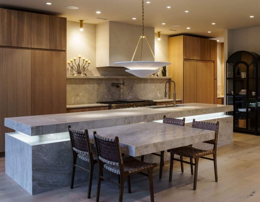 Custom kitchen with waterfall stone island and walnut cabinetry, built by Hickok Homes