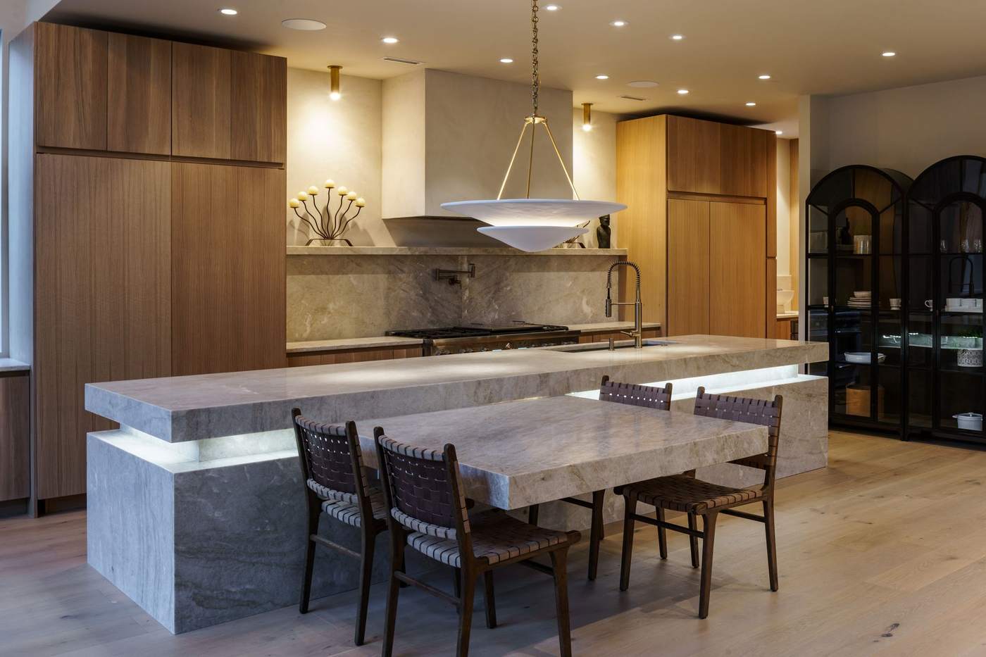 Custom kitchen with waterfall stone island and walnut cabinetry, built by Hickok Homes