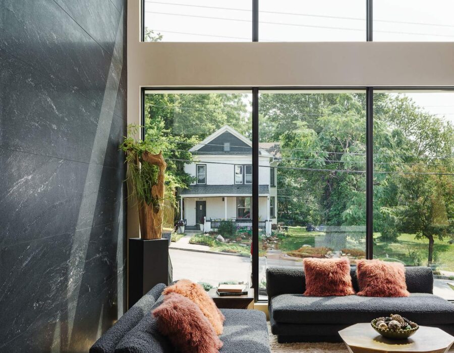 Cozy living room lounge with dark stone fireplace wall and designer furnishings