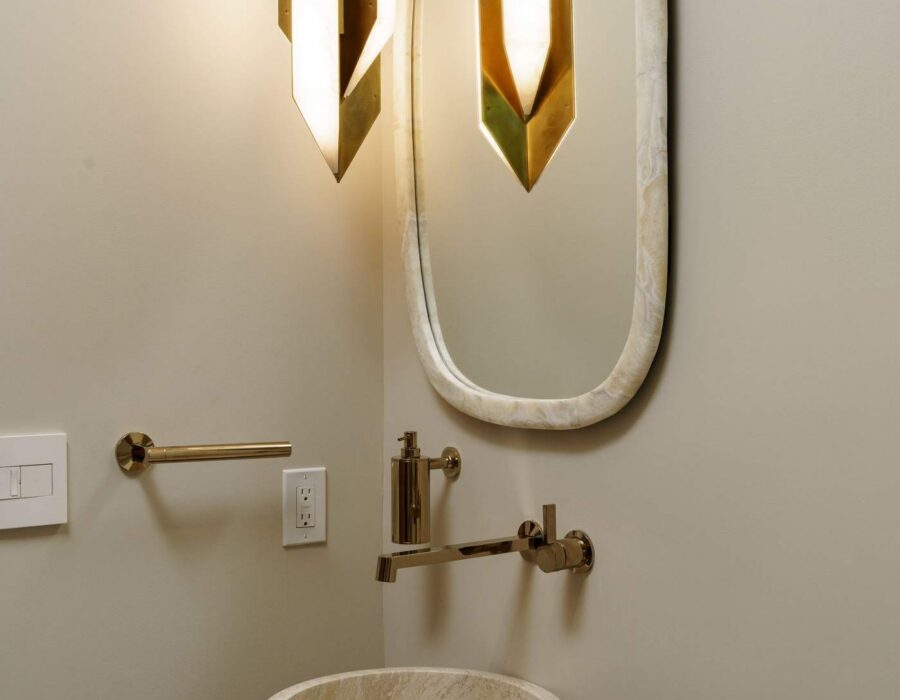 Powder room with sculptural pedestal sink and brass fixtures