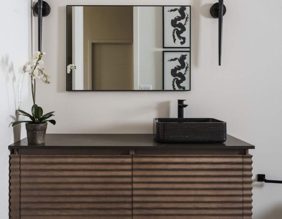 Bathroom vanity with floating wood cabinetry and round mirror
