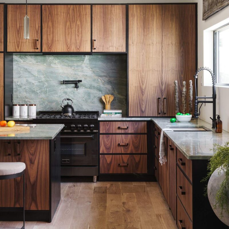 Full kitchen view with stone backsplash and integrated appliances