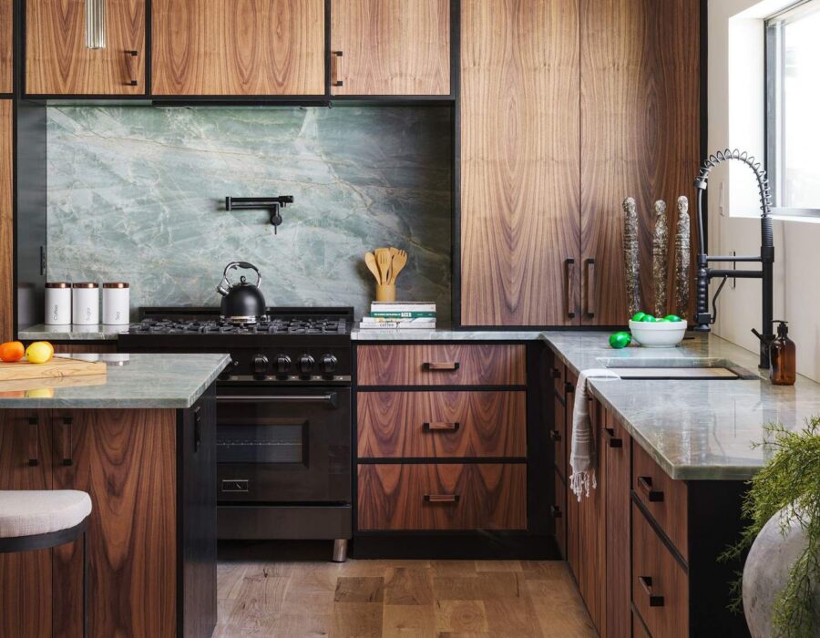Full kitchen view with stone backsplash and integrated appliances