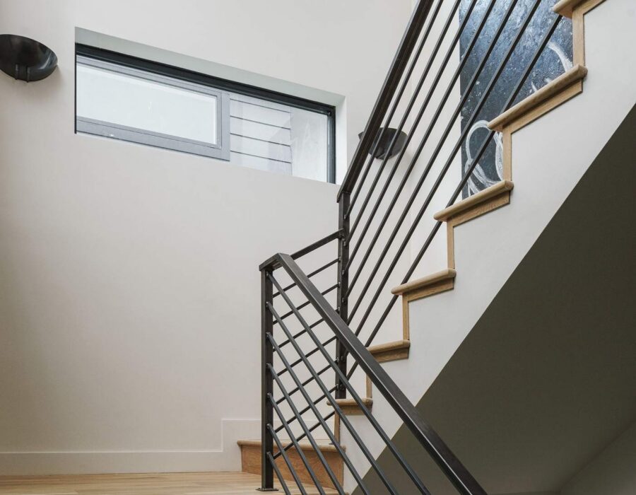 Modern open staircase with cable railing in a custom home