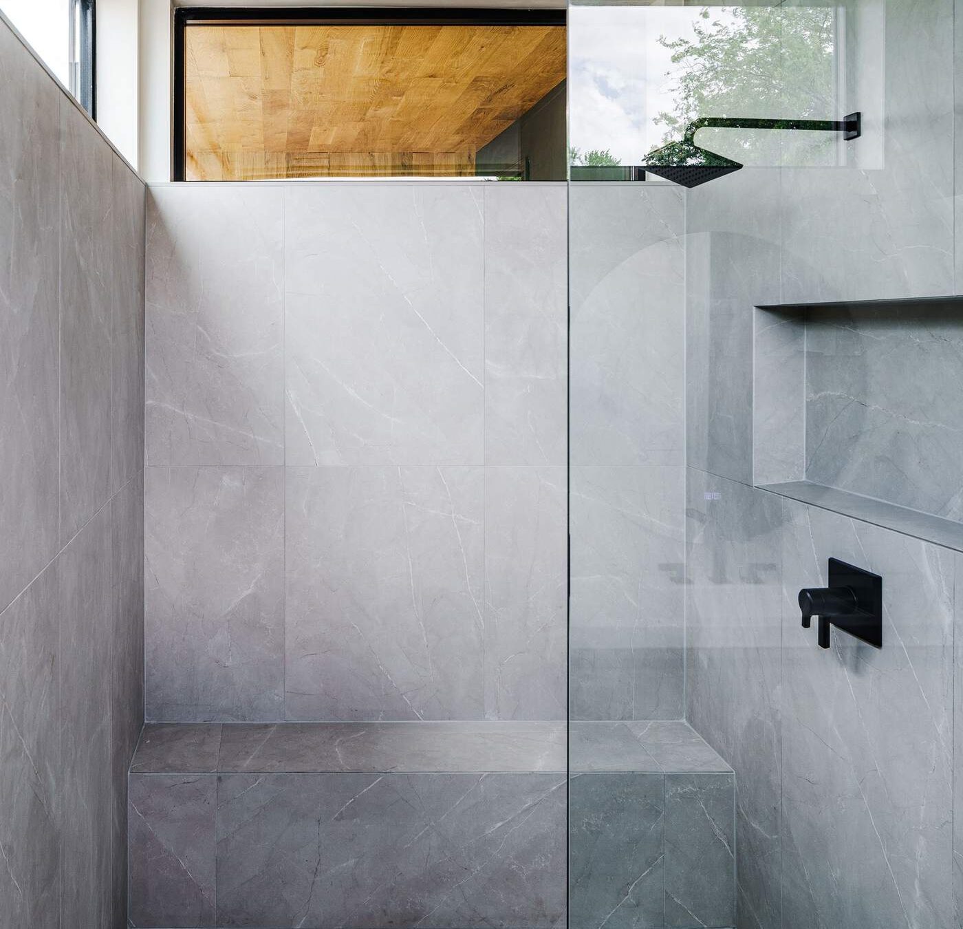 Frameless glass walk-in shower with concrete-look tile