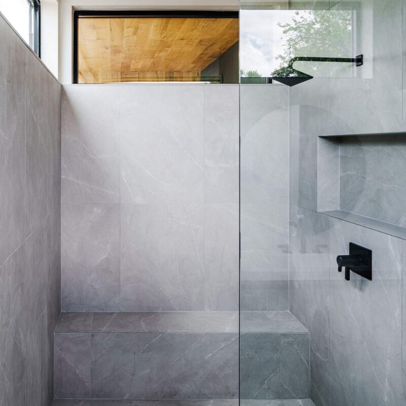 Frameless glass walk-in shower with concrete-look tile