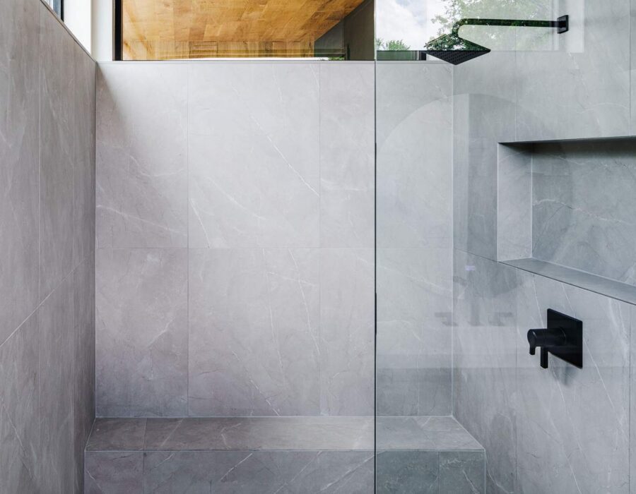 Frameless glass walk-in shower with concrete-look tile